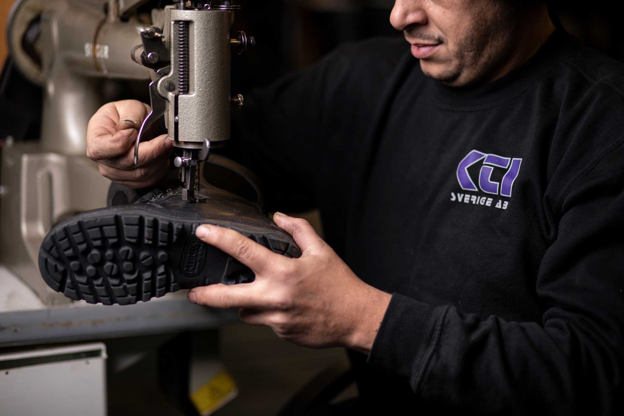 En medarbetare hos KTI reparerar en sko med hjälp av en maskin.