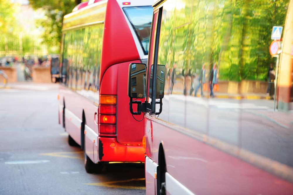 Två bussar som står parkerade efter varandra.