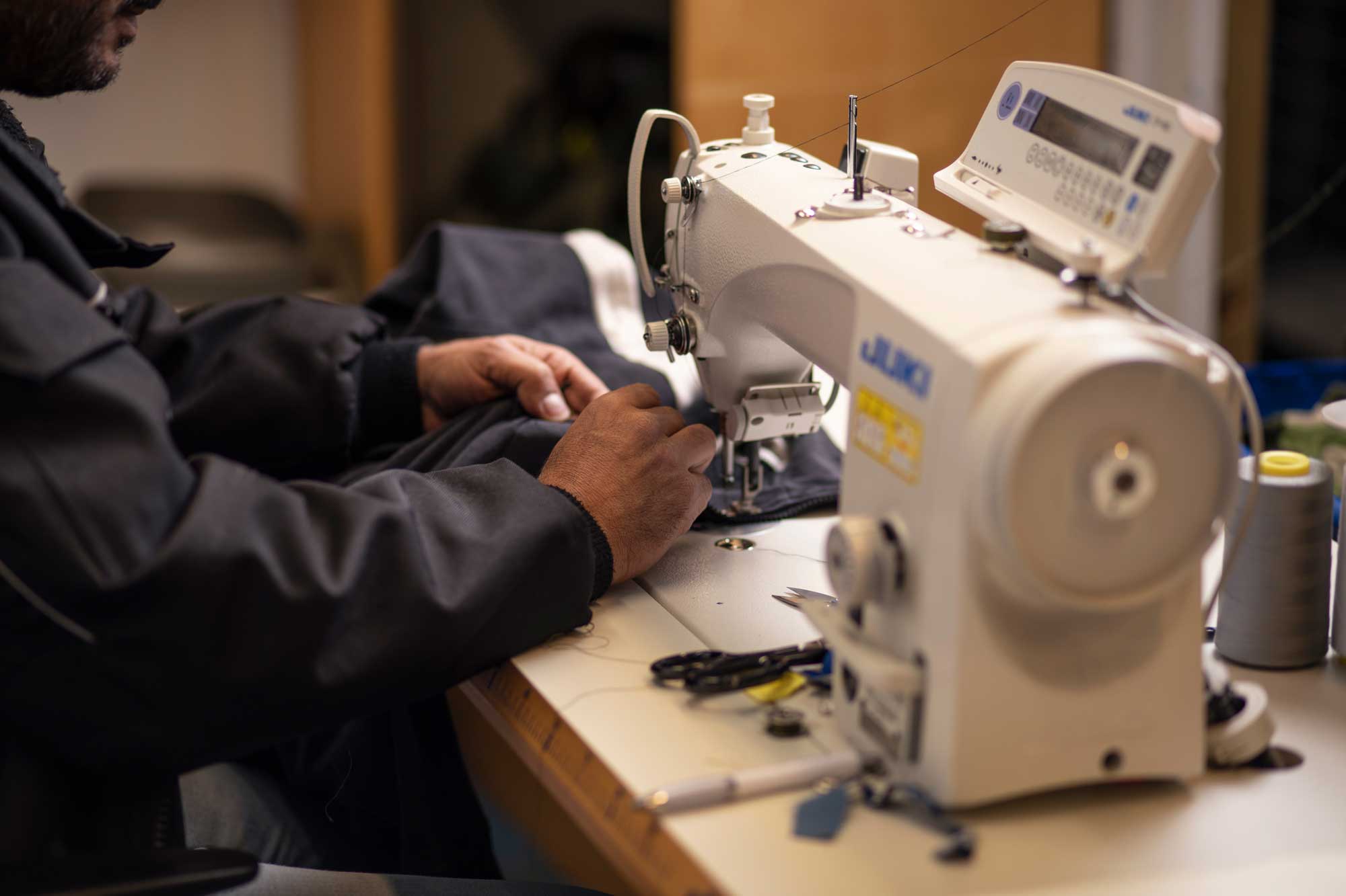 A person is using a sewing machine of some fabric.
